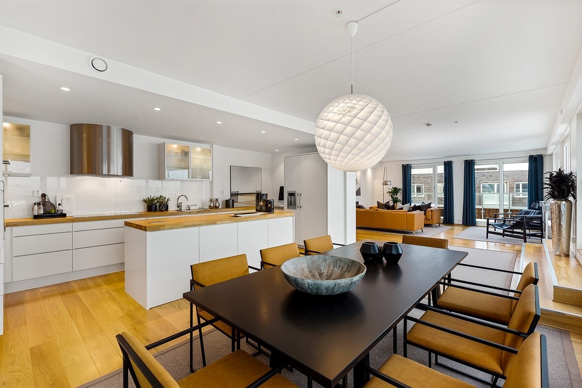 Kjøkken og stue ligger i åpen løsning, og sammen utgjør de et langstrakt og storslått allrom langs hele fasaden mot nordvest. Galleribilde