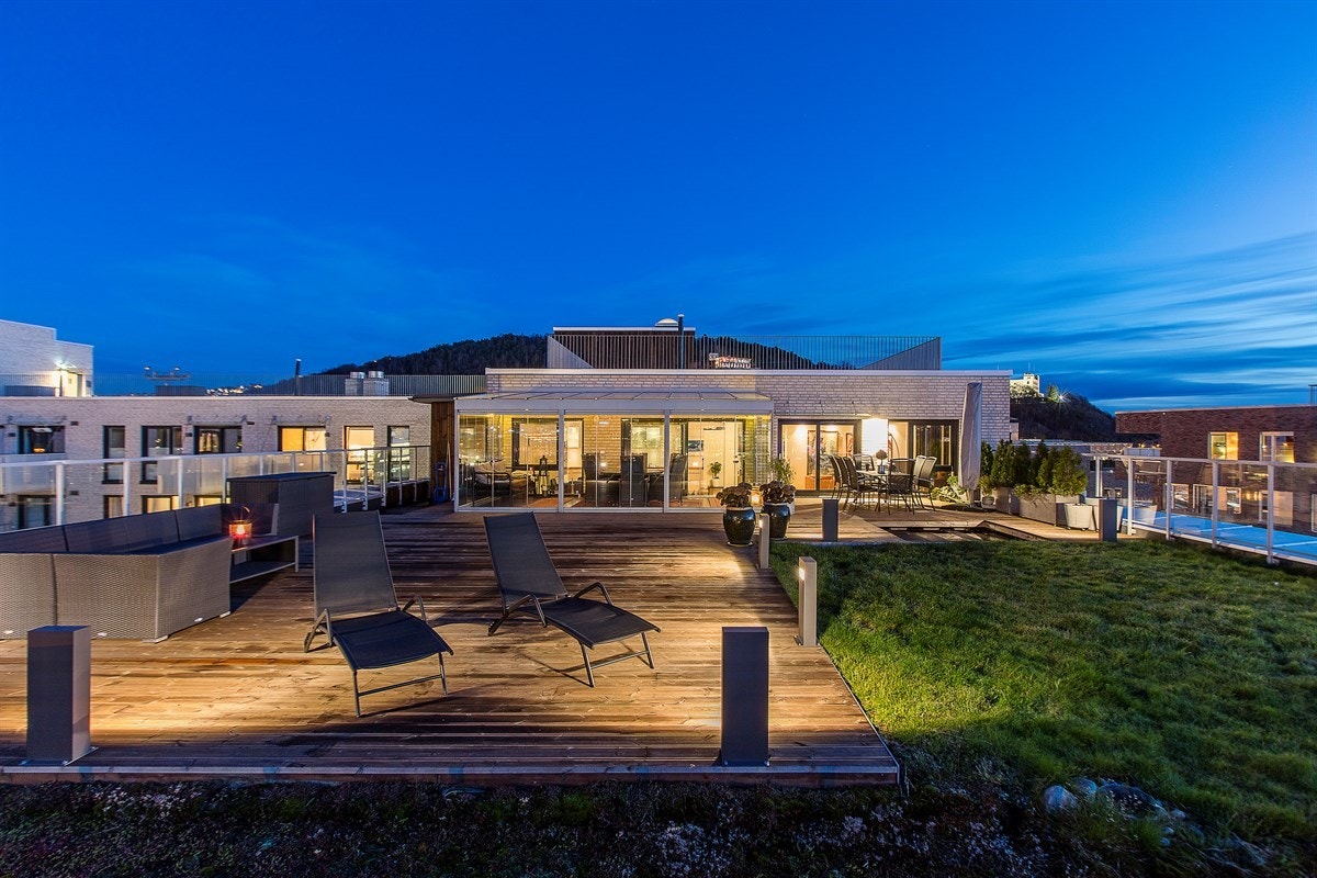 Leiligheten har også en langstrakt balkong på fasadens vestside, og fra stuen er det utgang til både takterrasse og balkong via skyvedører som åpner opp mellom ute- og innemiljø. Galleribilde