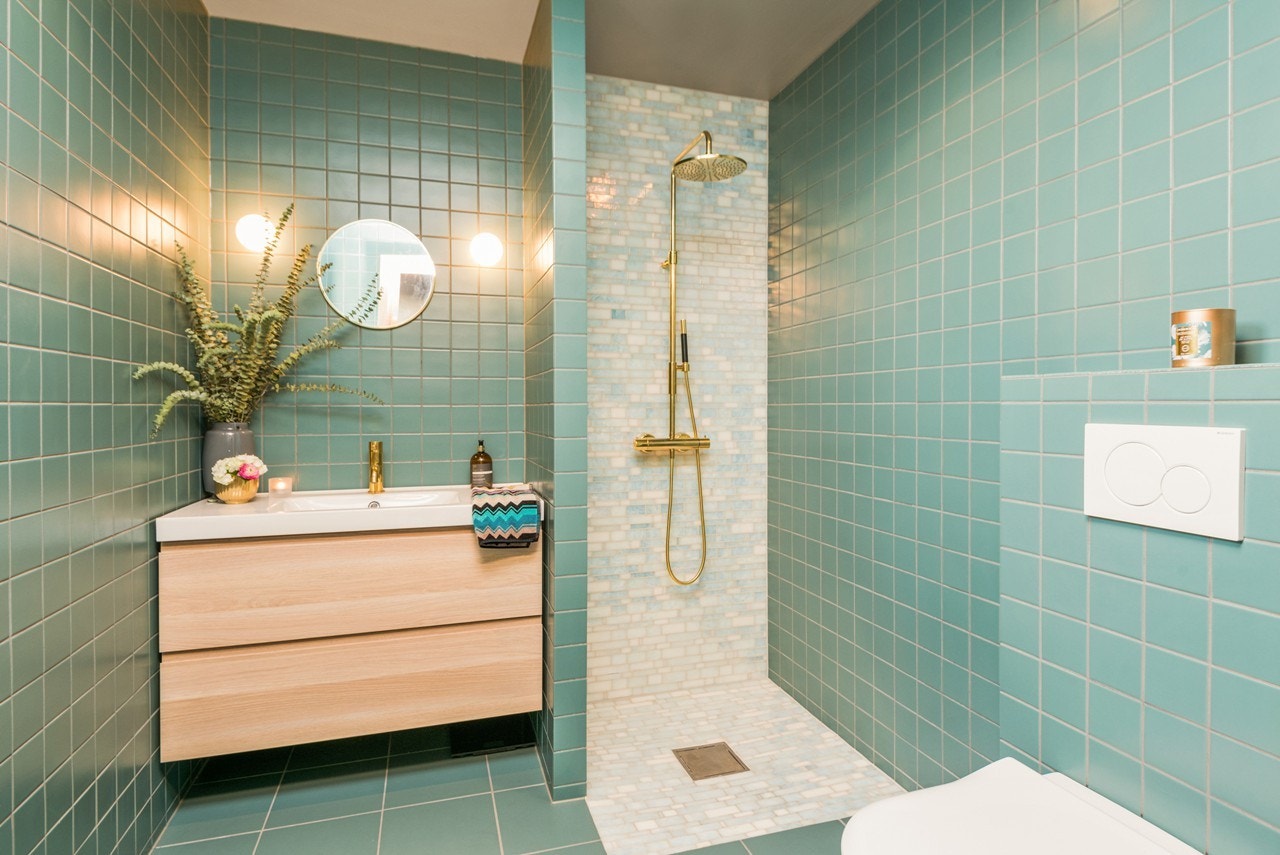 Badet i andre etasje har samme stilmessige uttrykk som badet i første etasje, og flislagte gulv og vegger i samme fargevalører. Badet har veggmontert toalett, dusjnisje med forgylt regnfallsdusj og håndholdt dusjgarnityr. Galleribilde