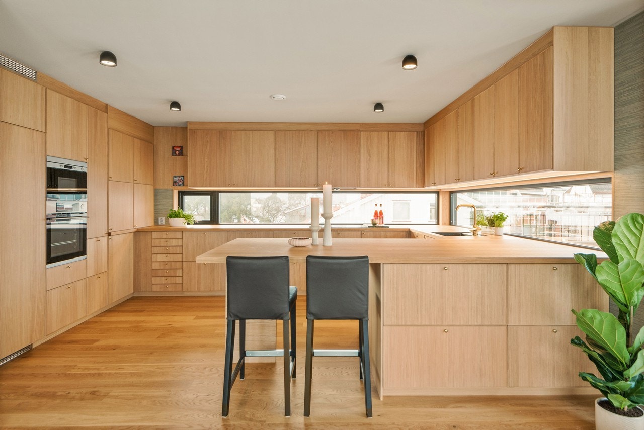 Kjøkkenet ligger i åpen løsning med stuen og er holdt i et lekkert, moderen design som gir meget god skap- og benkeplass. Den innerste veggen har plassbygde skap fra gulv til tak og rommet er naturlig avdelt fra stuen med en smart barløsning. Galleribilde