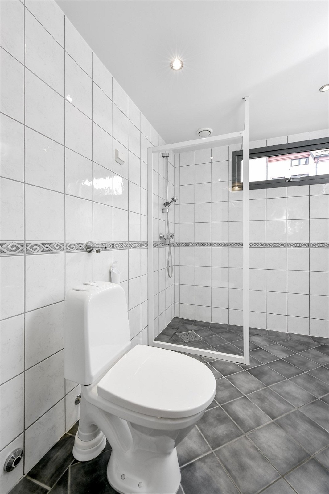 Badet er videre utstyrt med toalett, dusjhjørne med skjermvegg og opplegg for vaskemaskin. Galleribilde