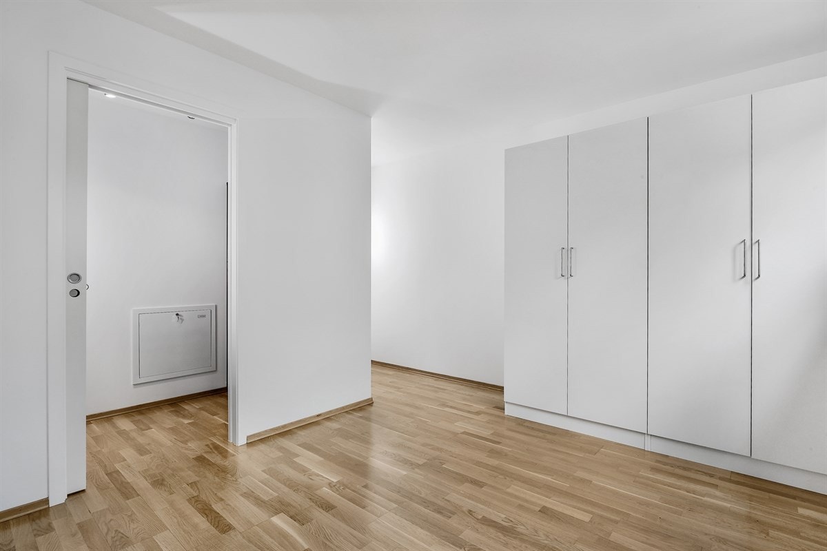 På det ene soverommet står det to garderobeskap, og rommet har et tilliggende, praktisk walk-in closet innredet med oppheng og hylleløsninger. Galleribilde