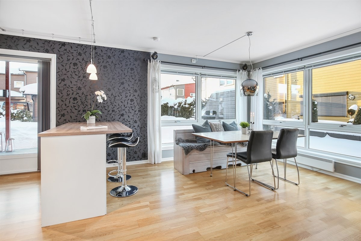 Stuen har store vindusflater som opprettholder nydelige lysforhold, parkett på gulv og vegger i en lun, tidsmessig gråfarge. Galleribilde