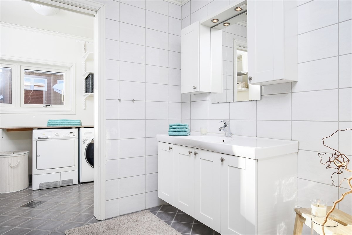 Innredningen holder en tidløs stil med lyse profilfronter og består av servantskap, veggskap og speil med overlys. Galleribilde