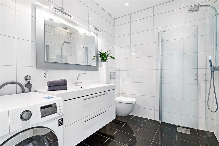 Meget pent, flislagt bad med dusj, toalett og opplegg for vaskemaskin Galleribilde