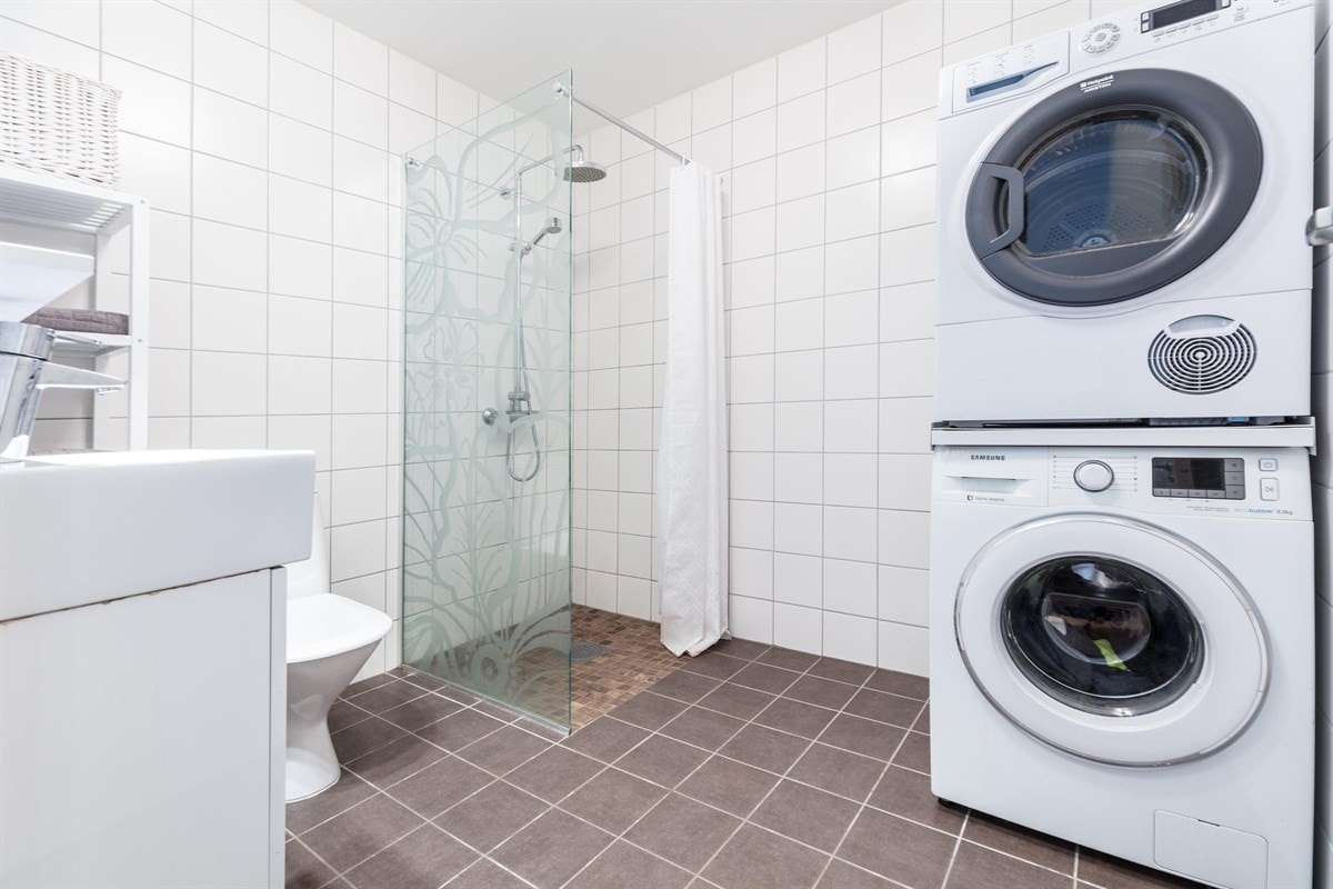 Innredningen består av servantmøblement med toppmontert servant, speil med overbelysning, toalett og separat dusjnisje med glassvegg. Opplegg og plass for vaskemaskin og tørketrommel. Galleribilde