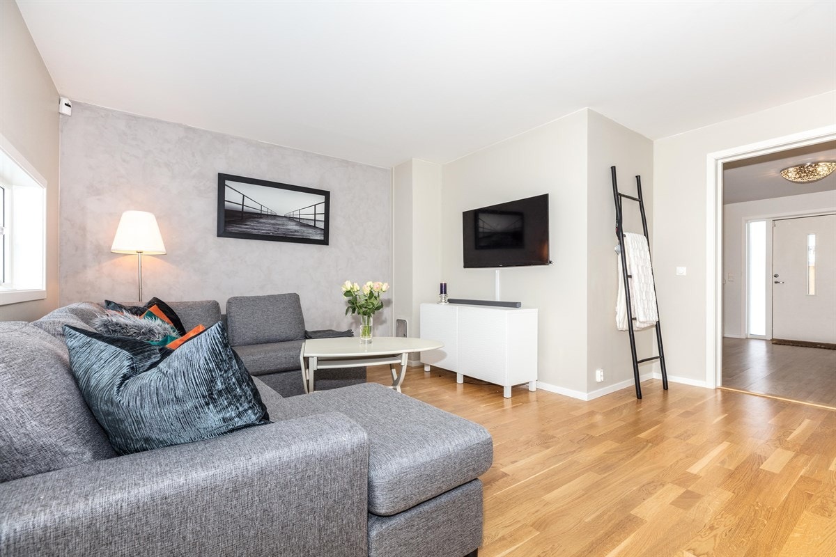 Stuen har nymalte slette overflater med en mørkere kontrastvegg, og flott slitesterk parkett på gulv. Galleribilde