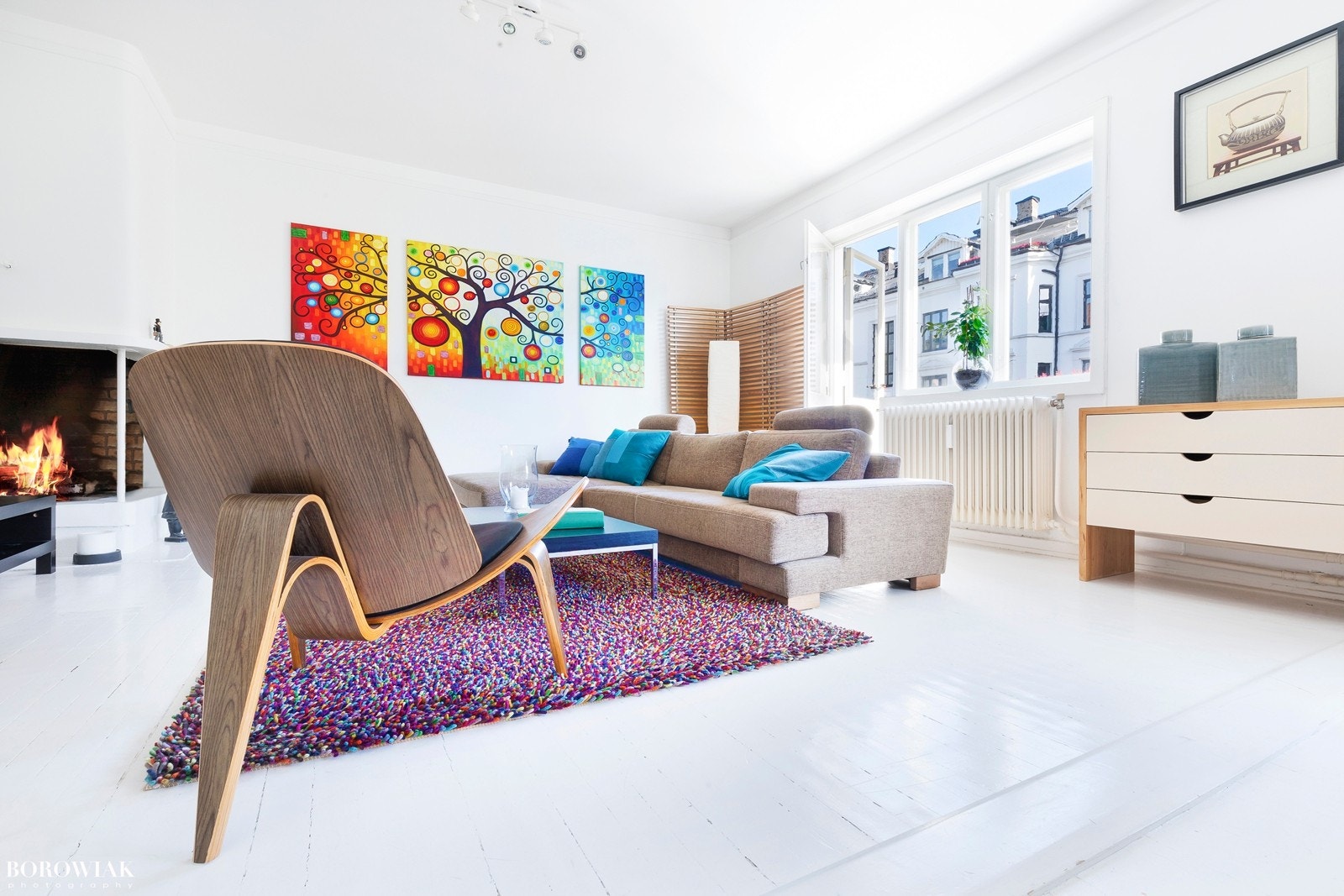 Store vindusflater preger stuen og slipper inn godt med lys. Hyggelig utsyn mot rolig gate preget av frodige forhager Galleribilde