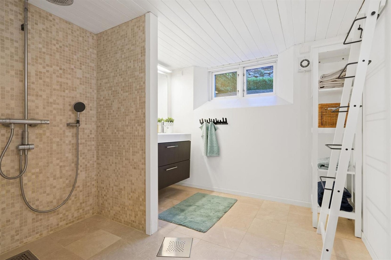 Stort og moderne bad i husets underetasje. Her er det også overgang til sone for vaskemaskin. Galleribilde