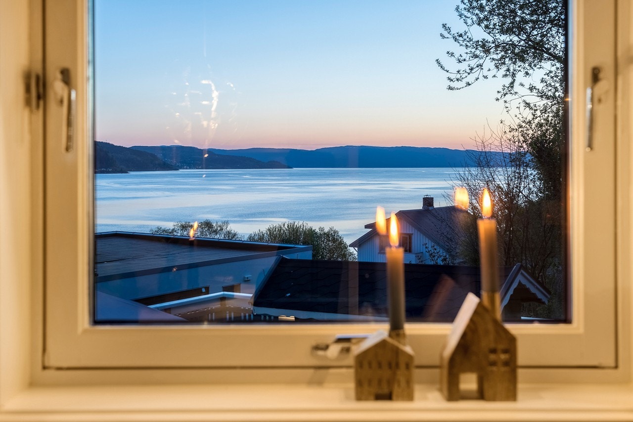 Fra vindusflatene rundt om i boligen får du vakre utsnitt av fjorden. Galleribilde