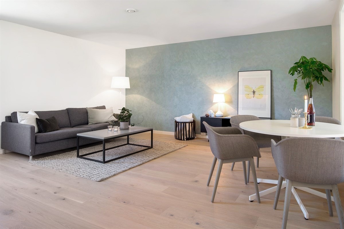 En kalkmalt vegg i en dus grønntone gir rommet ekstra karakter og stemning. Galleribilde