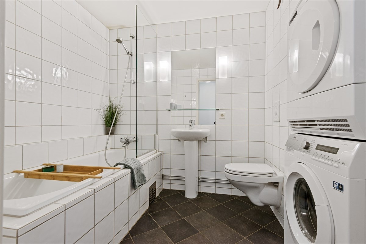 Pent, flislagt bad/wc med varme i gulv. Badet er av god størrelse, og har blant annet innmurt badekar med pen glassvegg. samt plass til vaskesøyle Galleribilde