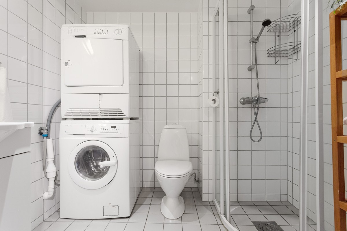 Badet er flislagt og lys med vegghengt klosett og badromsinnredning med servant, underskap og speil. Galleribilde