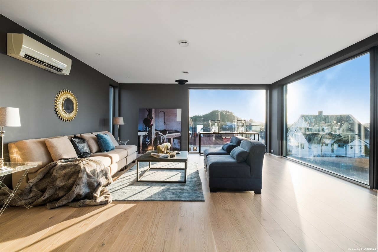 Stuen er malt i en lekker gråfarge, det er eikeparkett på gulv og spotter i tak. Galleribilde