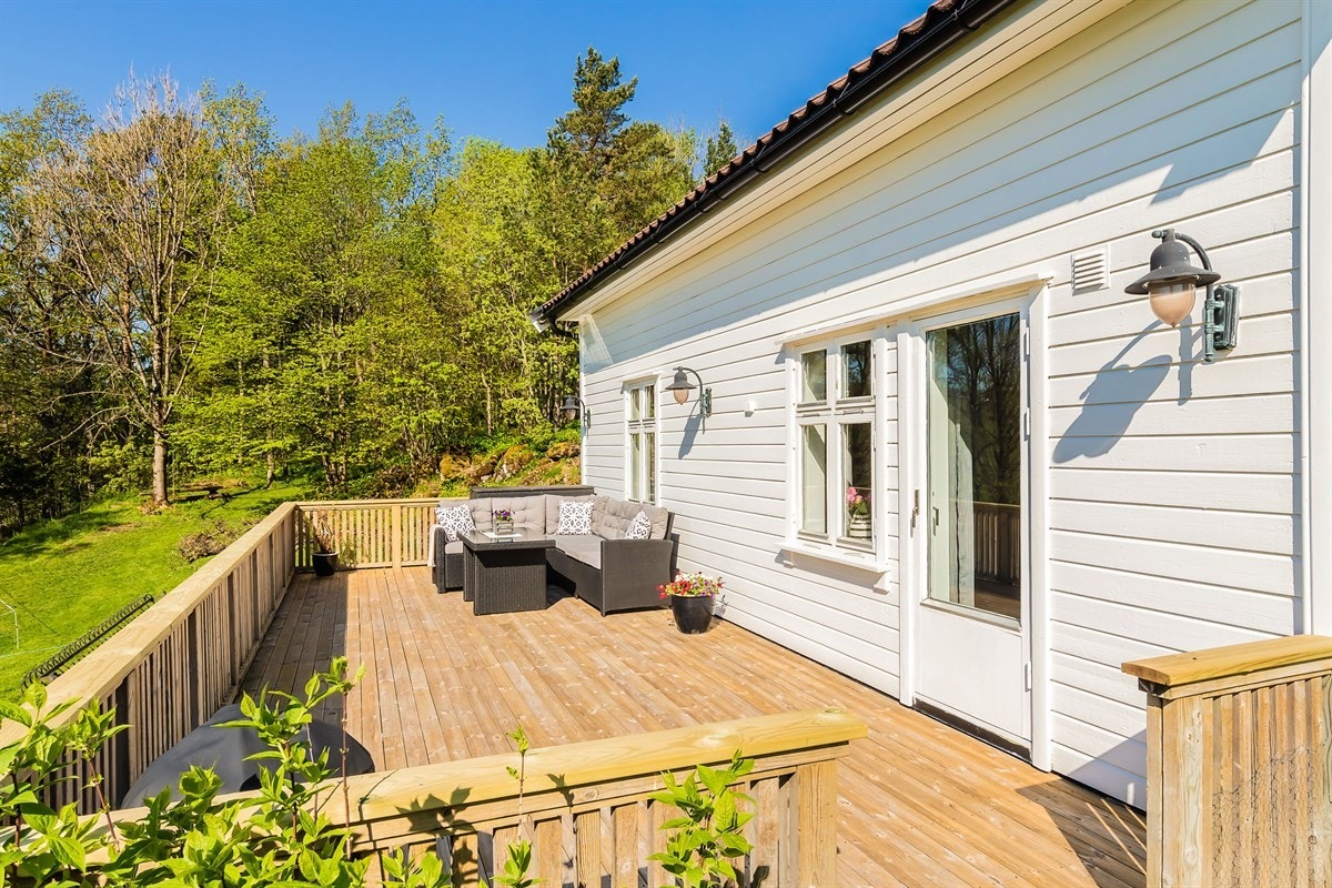 Stor sydvendt terrasse med flott utsikt over landbruksområder og skog Galleribilde