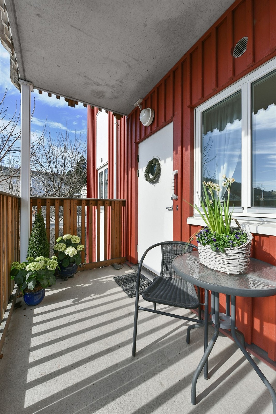 Ved inngangspartiet er det en overbygget uteplass med plass for både kafésett og blomsterkrukker. Galleribilde