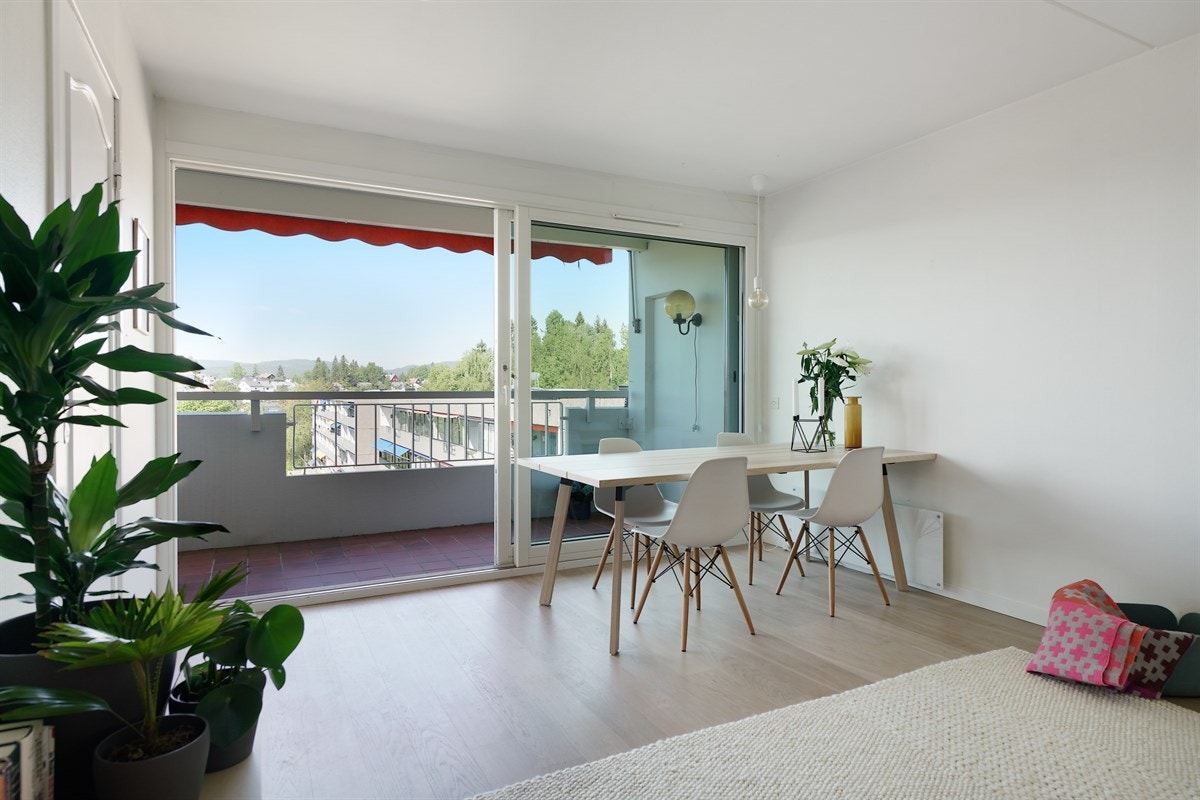 Stor skyvedør mot balkong gir mye lys inn i leiligheten. Galleribilde