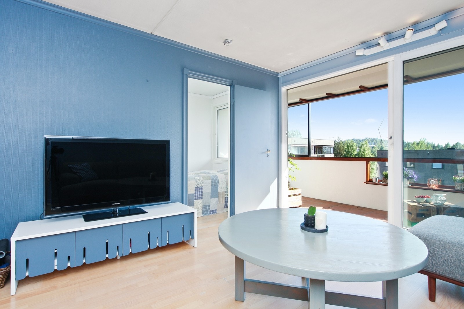 Lys stue med store vinduer og skyvedør ut til balkongen. Galleribilde