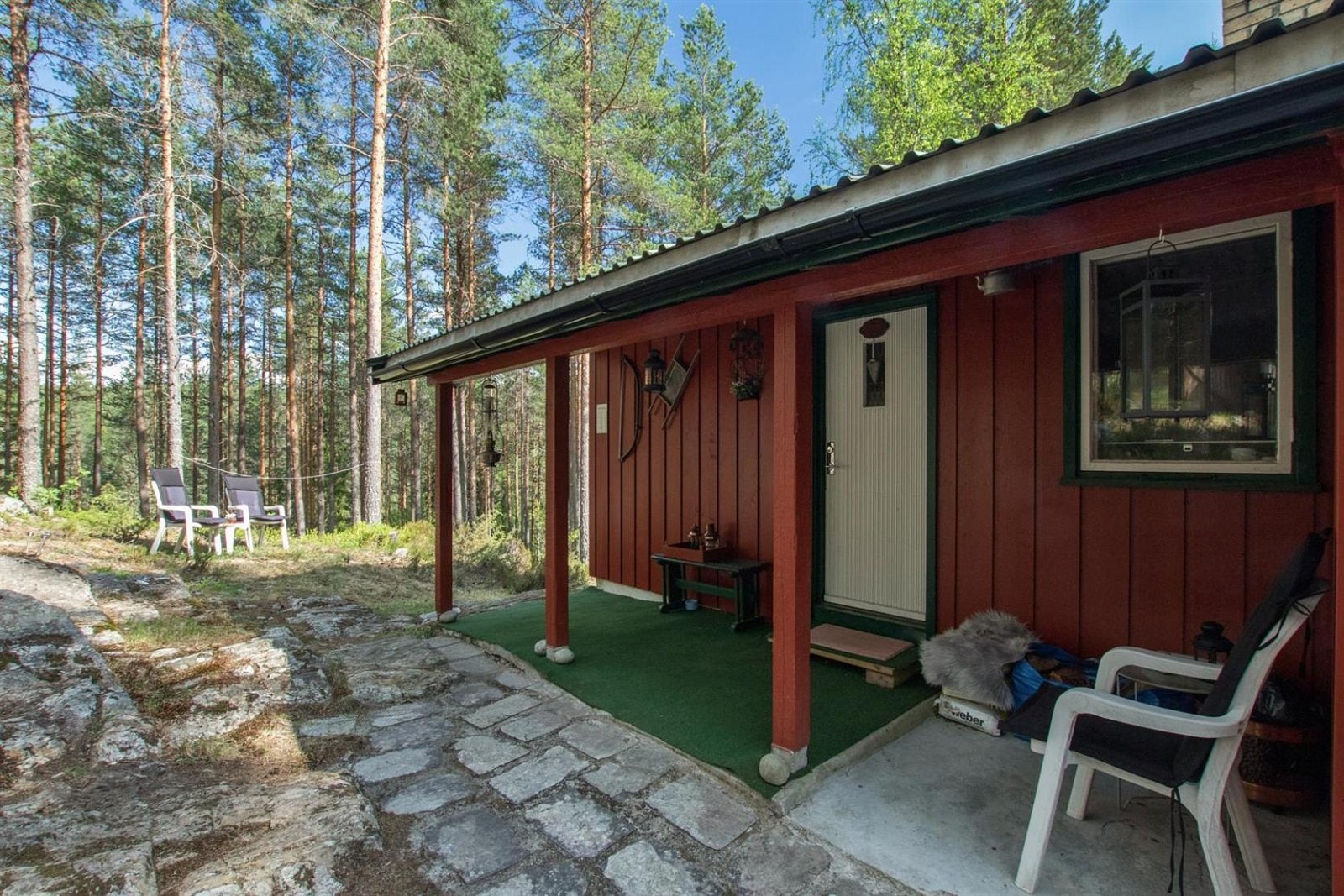 Pent overbygget inngangsparti med koselig beleggningsstein rett utenfor. Galleribilde