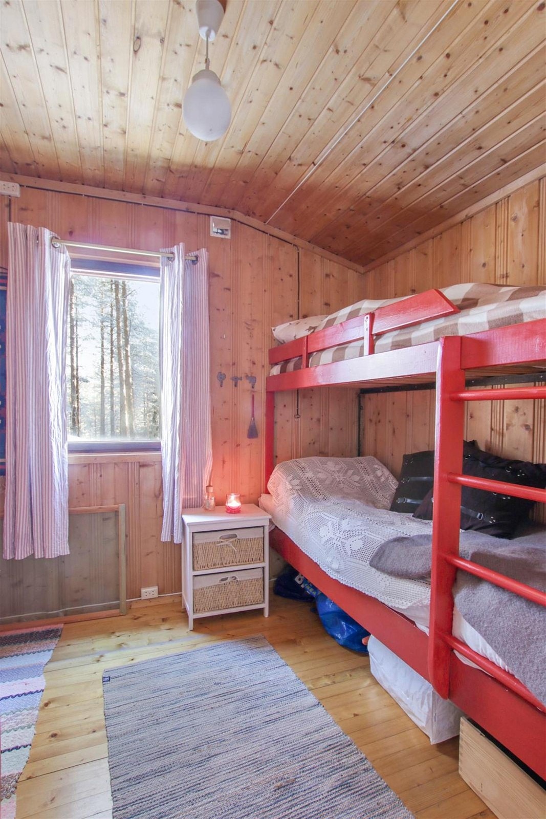 Et av de to praktiske soverommene har køyeseng og koselig utsikt ut til skogen. Galleribilde
