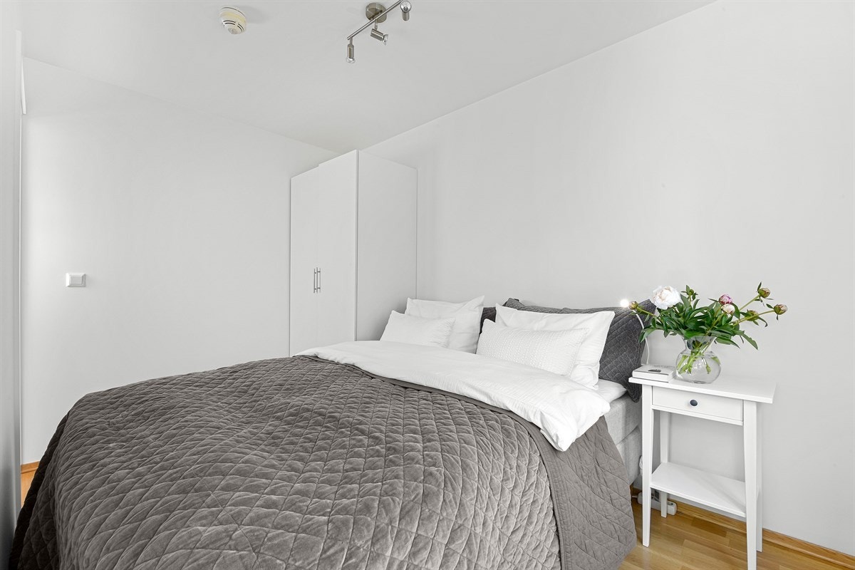 Leiligheten har et pent soverom med lyse veggflater, trestavs parkettgulv og to innganger fra stuen. Galleribilde