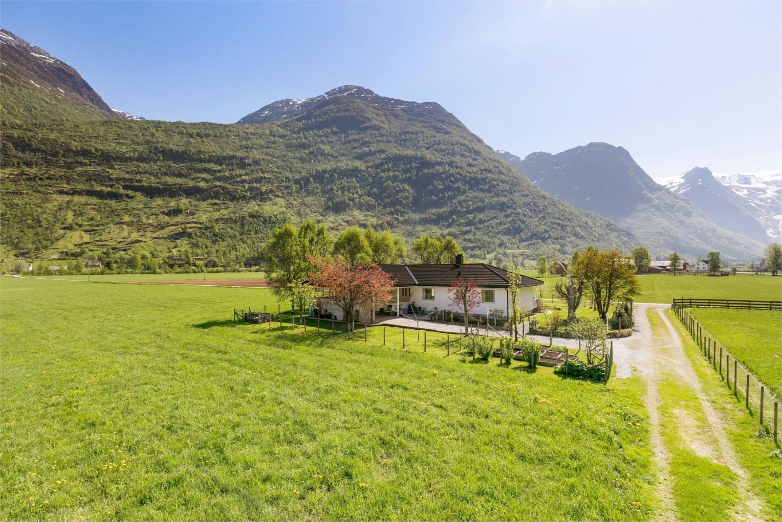 Her bur ein usjenert, omkransa av fjell og landbruk Galleribilde