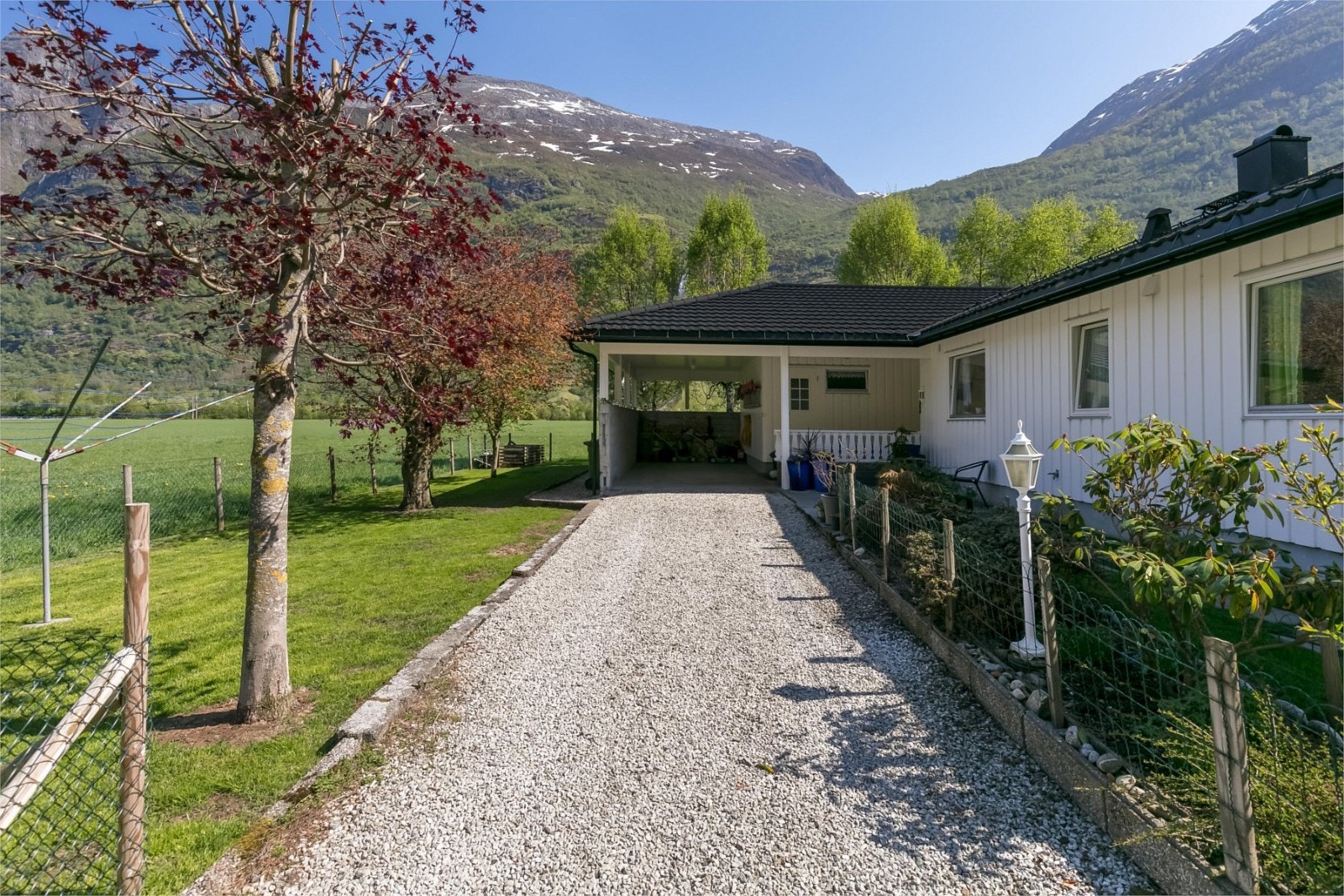 Grusa innkjørsel til carporten gir gode parkeringstilhøve på eigedomen Galleribilde