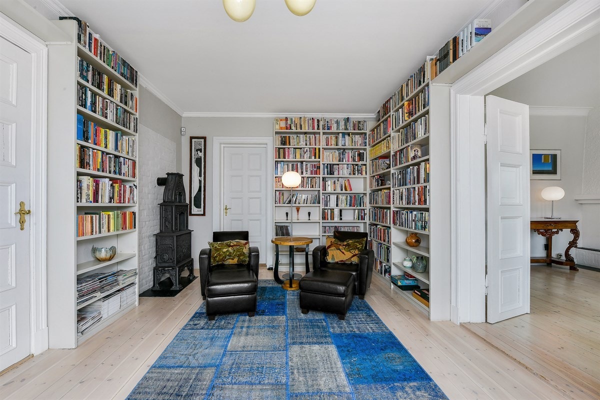 Biblioteket har plassbygde hyller og en antikk etasjeovn. Galleribilde