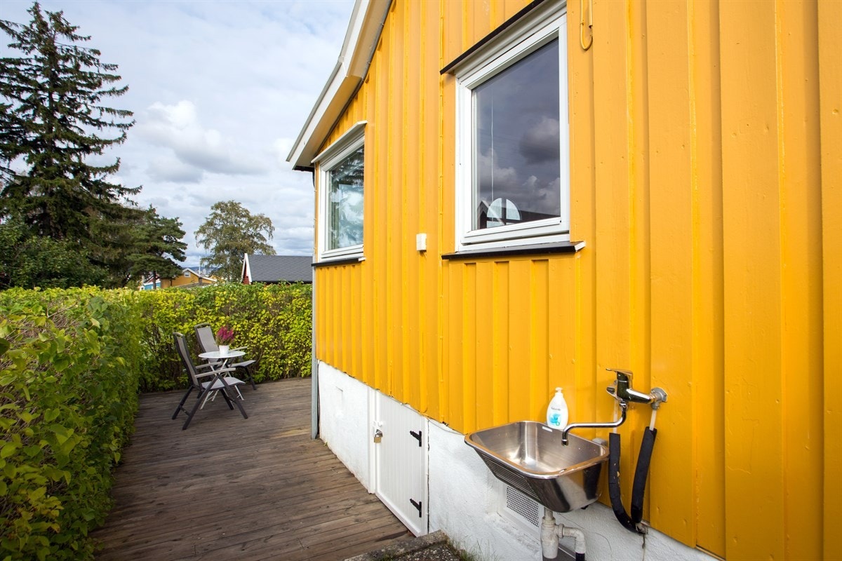 Sittegruppen på terrassen. På veggen er det montert en rustfri kum. Galleribilde