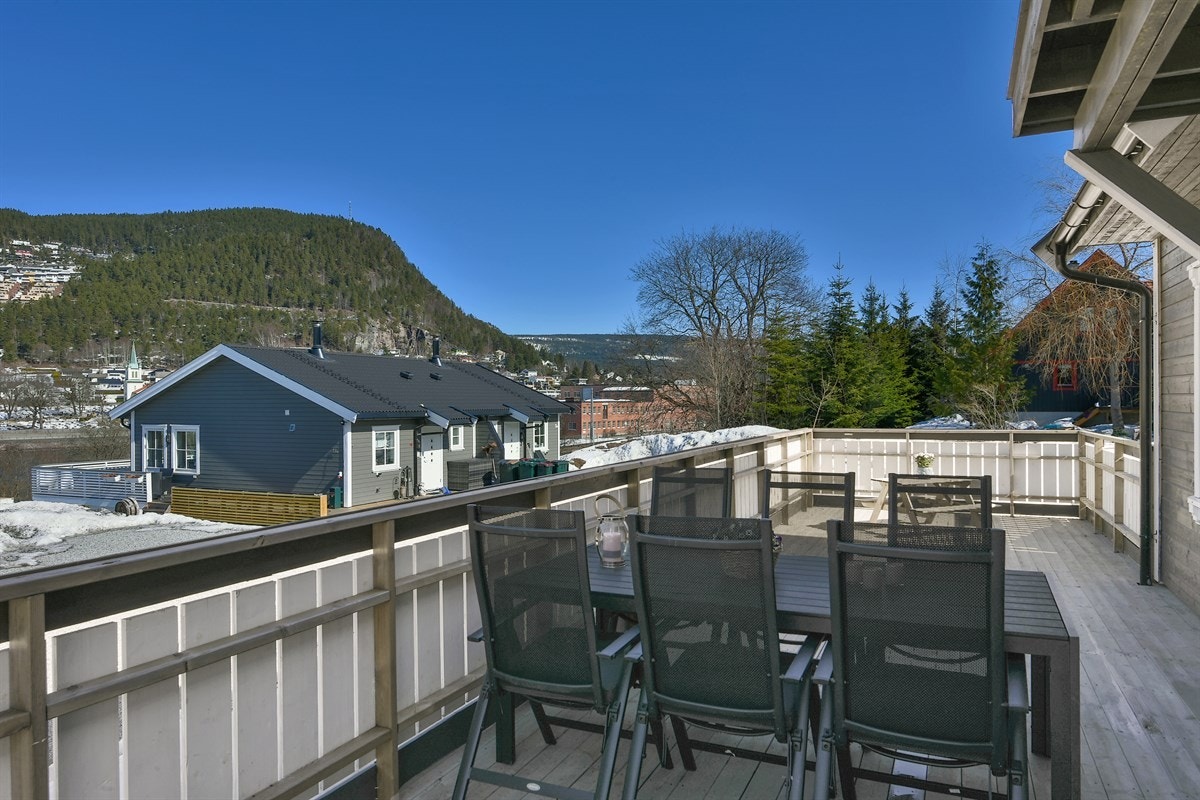 Terrassen har tredekke og omkranses av et forholdsvis tett, hvitmalt rekkverk. Galleribilde