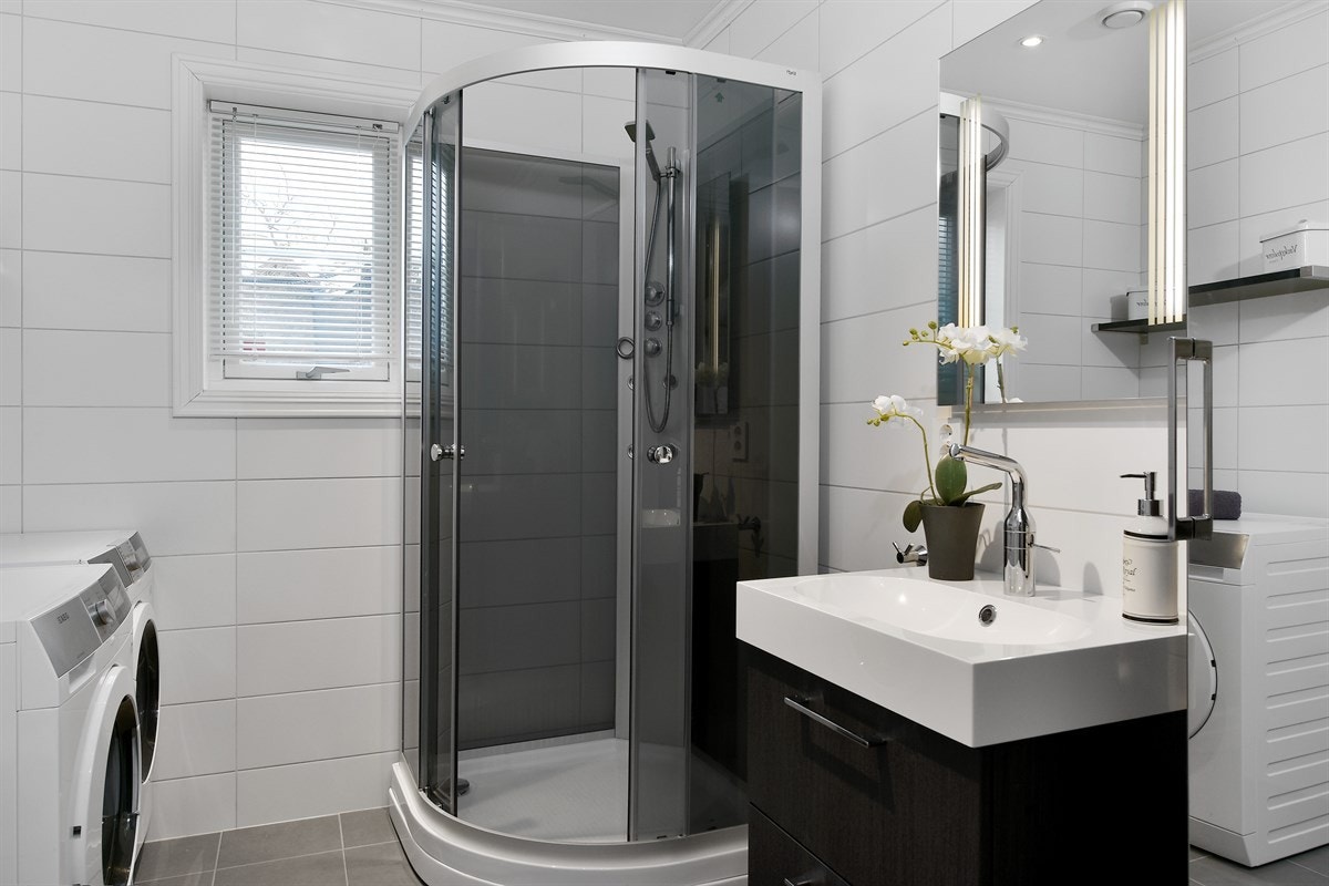 Boligen inneholder to innbydende, moderne bad, ett i hver etasje. Rommene har helflisede overflater med store, tidløse fliser, lun gulvvarme og downlights. Galleribilde