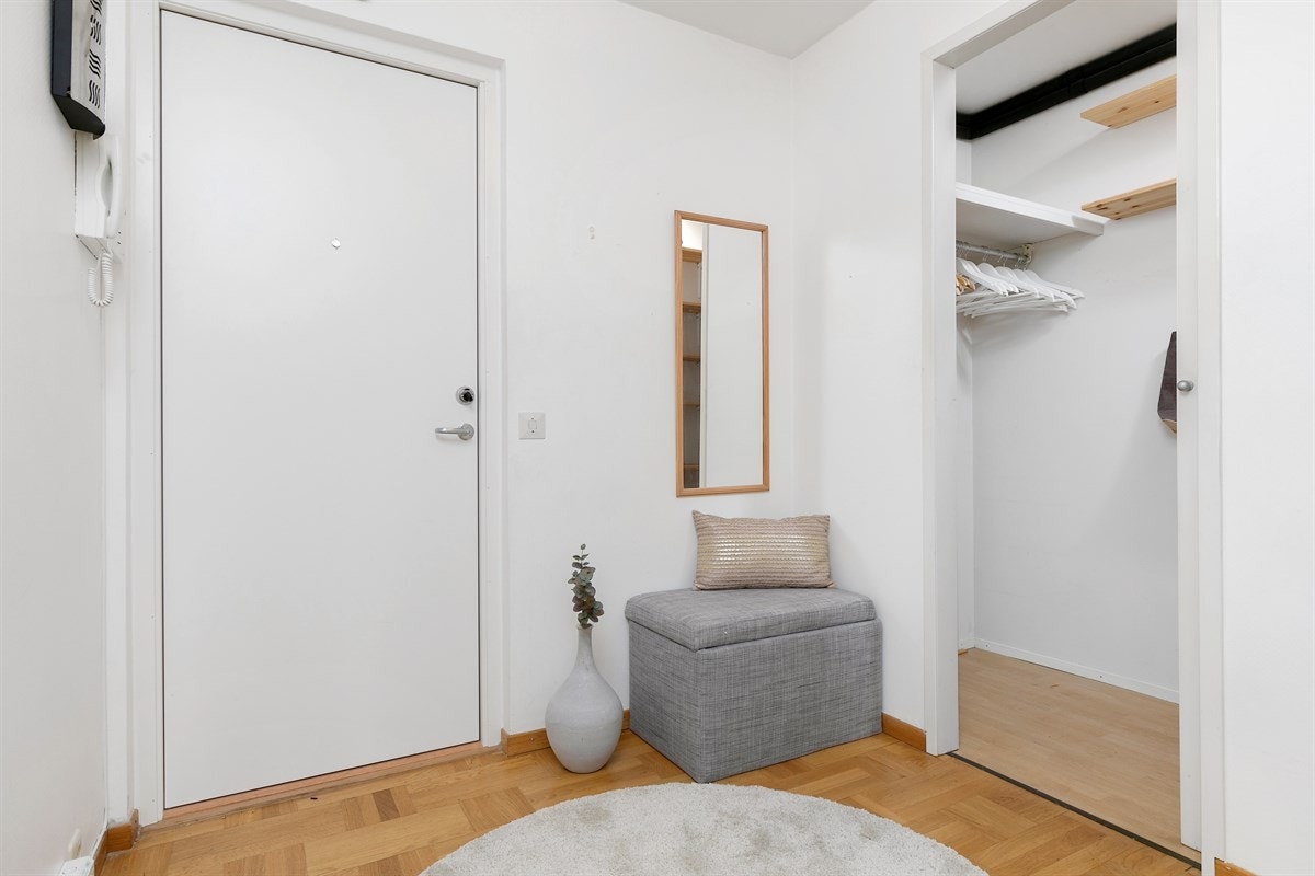 Innbydende entré med plass til oppbevaring av yttertøy og sko. Dørcalling med portåpner. Galleribilde