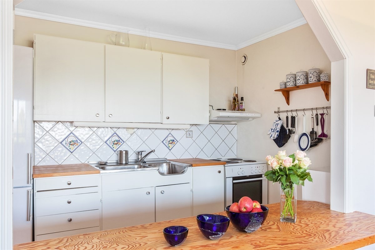 Hyggelig kjøkken med malte fronter og benkeplater i tre. Galleribilde