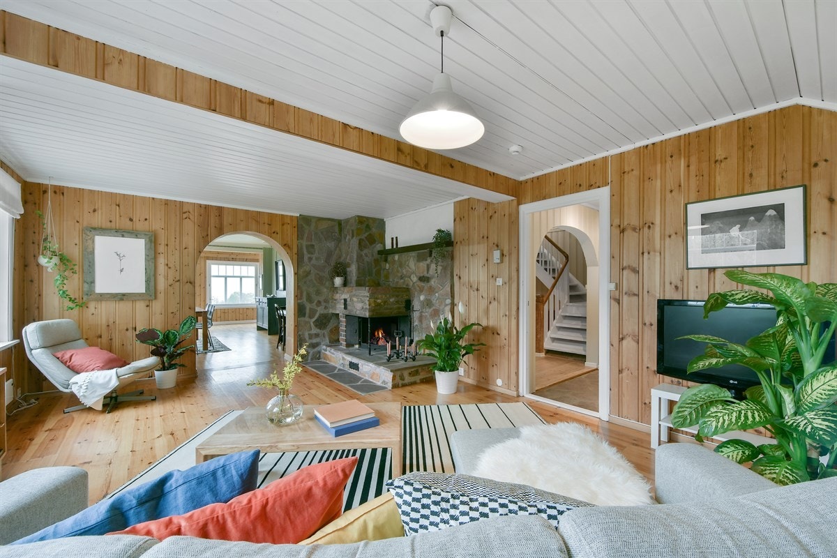 Vinduer på to sider gir godt lysinnslipp og en oppmurt peis i naturstein bidrar til stemningsfull hygge. Galleribilde