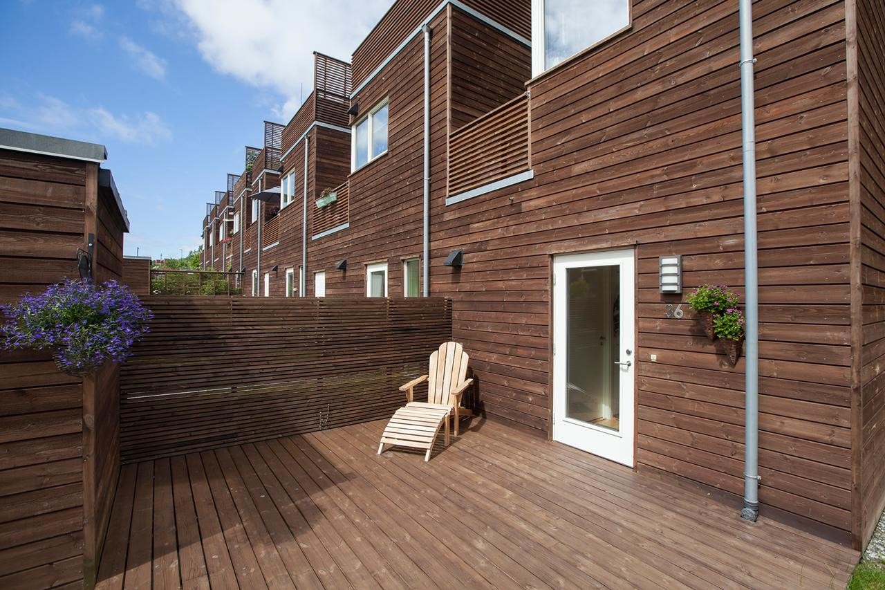 Stor solrik terrasse vendt mot sør med inngang til boligens underetasje Galleribilde