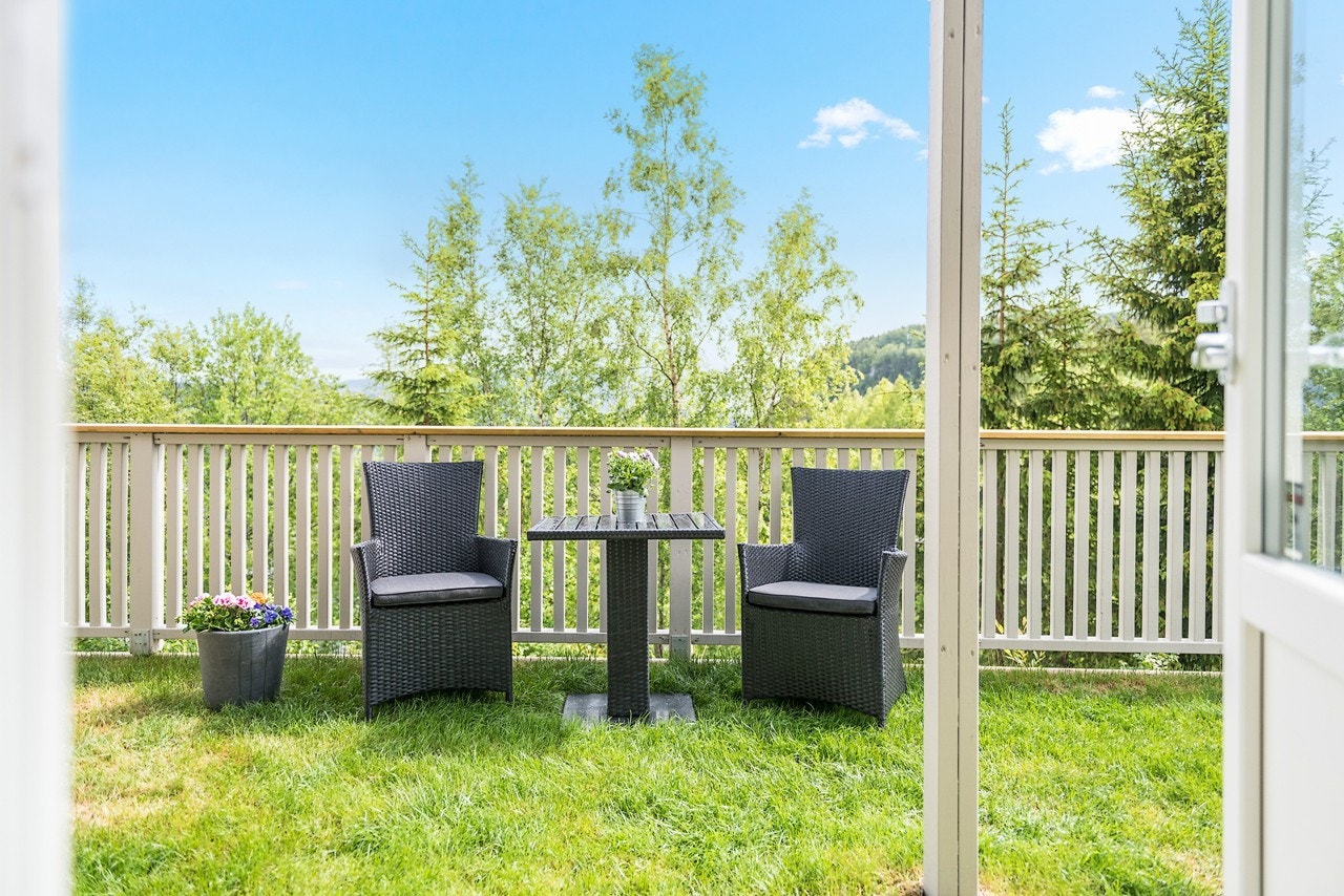 Koselig, inngjerdet hageparsell med adkomst fra gang i sokkeletasjen og utvendig trapp. Galleribilde