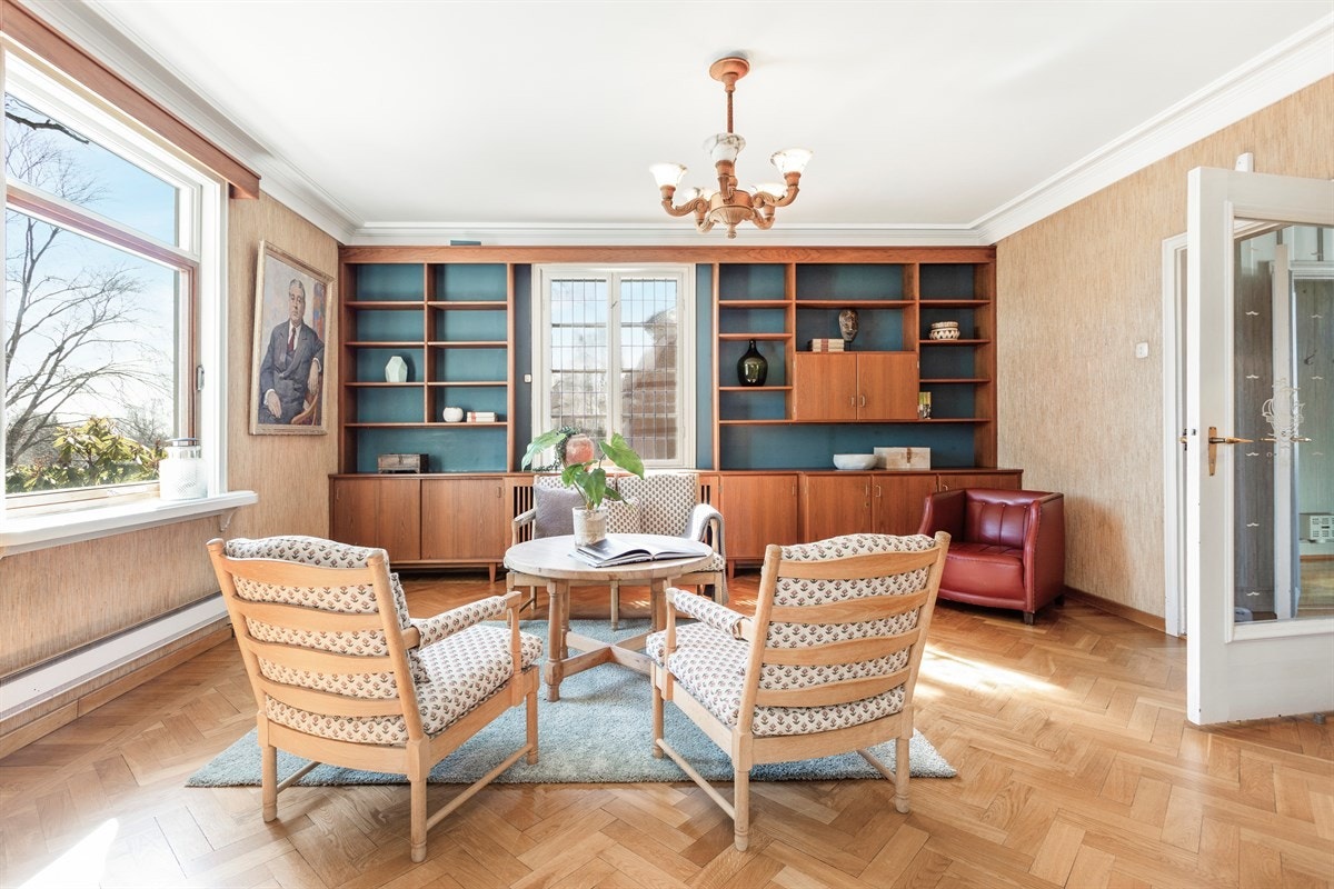 Bibliotek med plassbygget bokhylle, vindu med blyglass og vedkamin Galleribilde