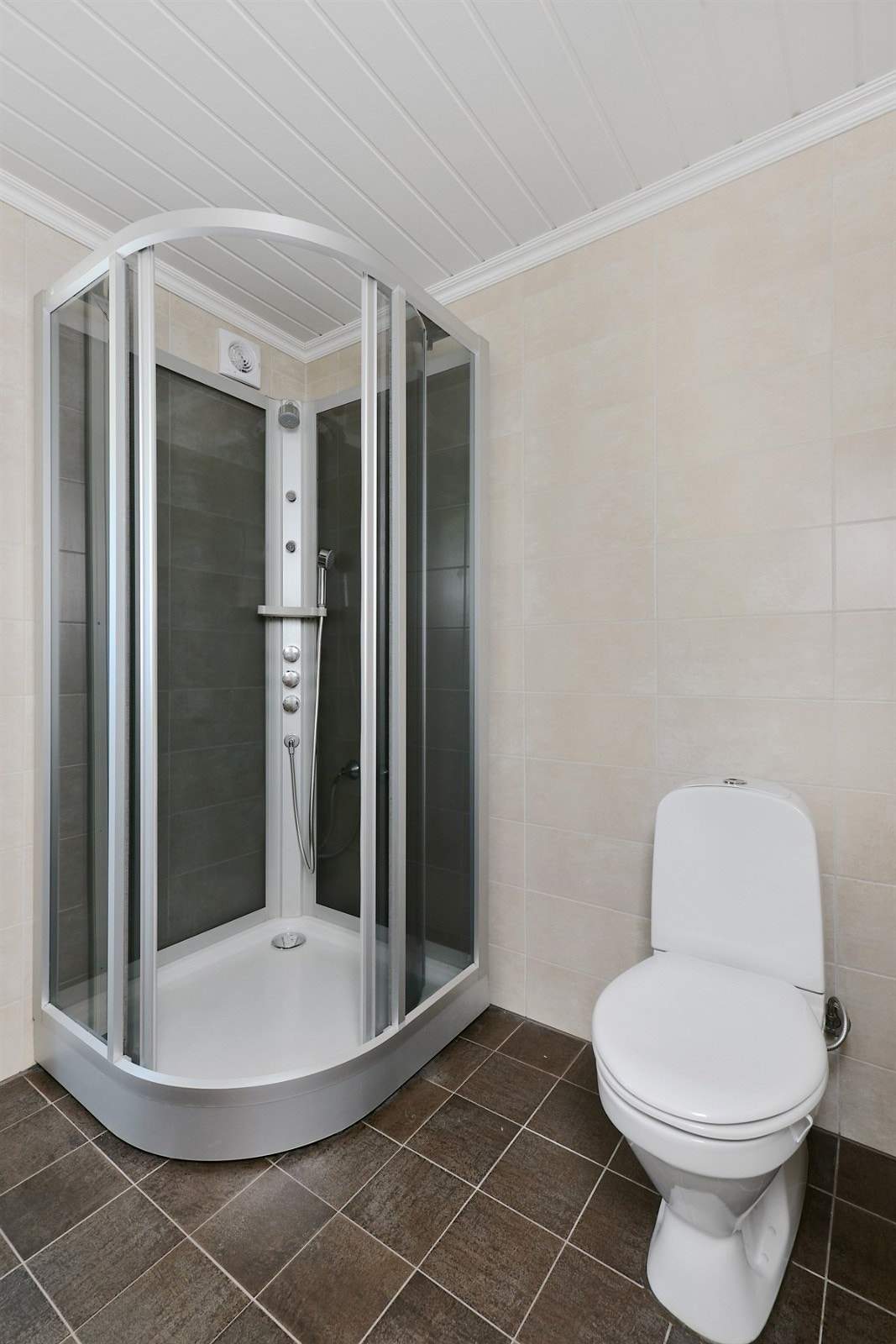 Boligen inneholder to bad og et separat vaskerom. Badet i første etasje fremstår som et praktisk familierom med lyse, delikate veggfliser og mørke gulvfliser med lun gulvvarme. Galleribilde