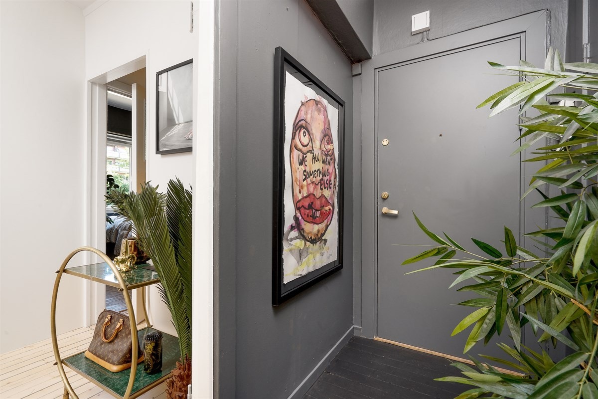 Hyggelig entré med mørkmalte vegger og gulv setter et stilig preg på leiligheten. Galleribilde