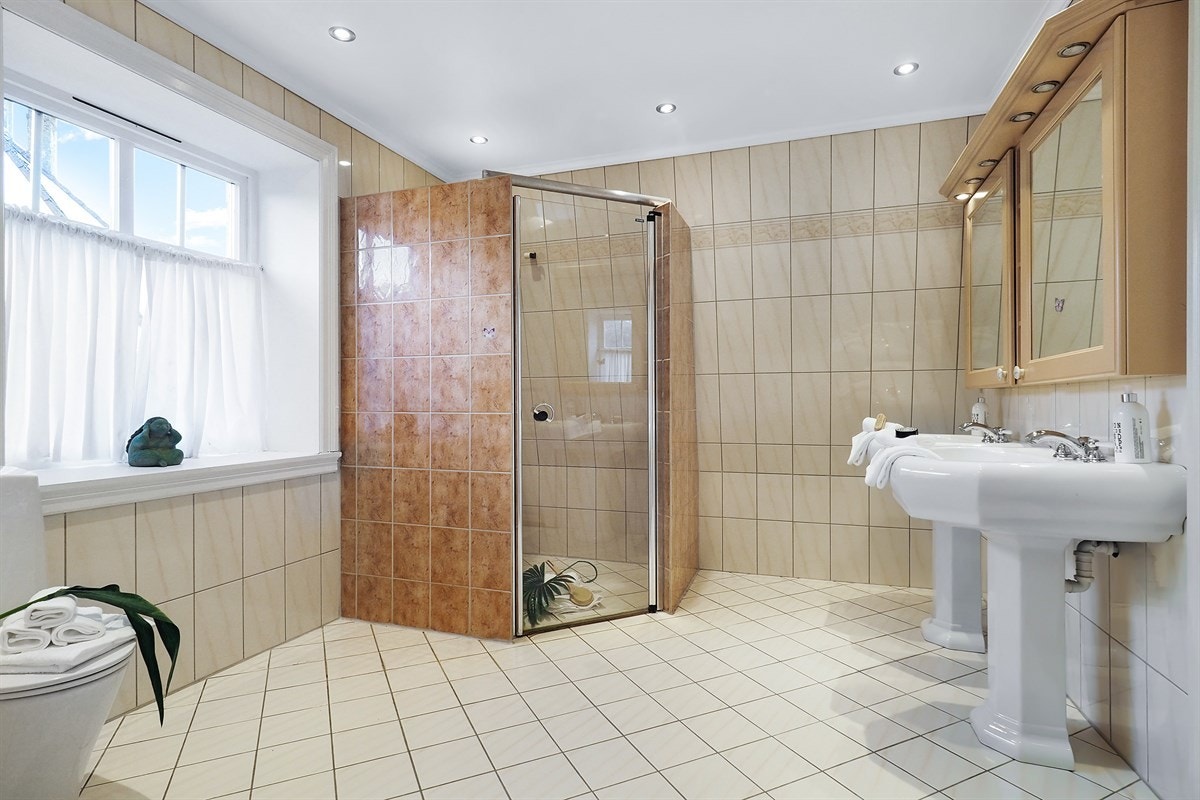 Pent helfliset bad med to servanter, fliset dusjnisje og wc. Galleribilde