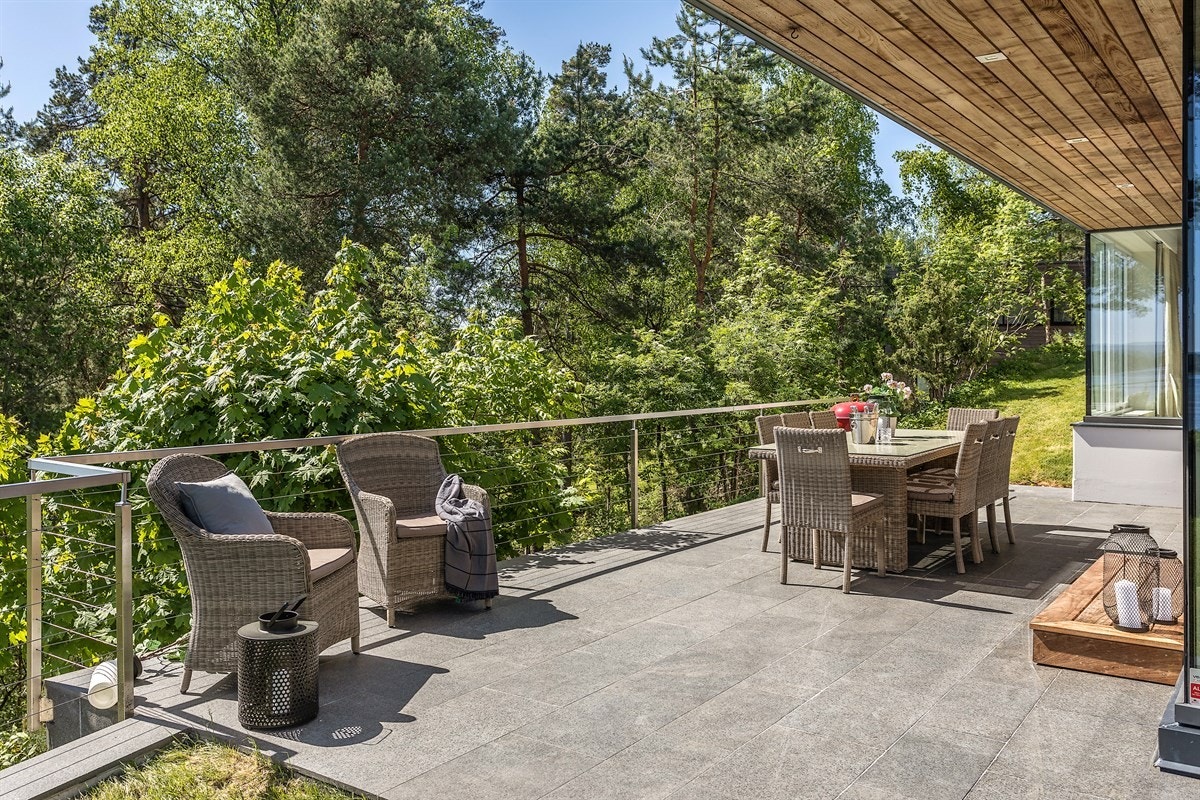 Utgang til usjenert, flislagt terrasse fra spisestuen Galleribilde