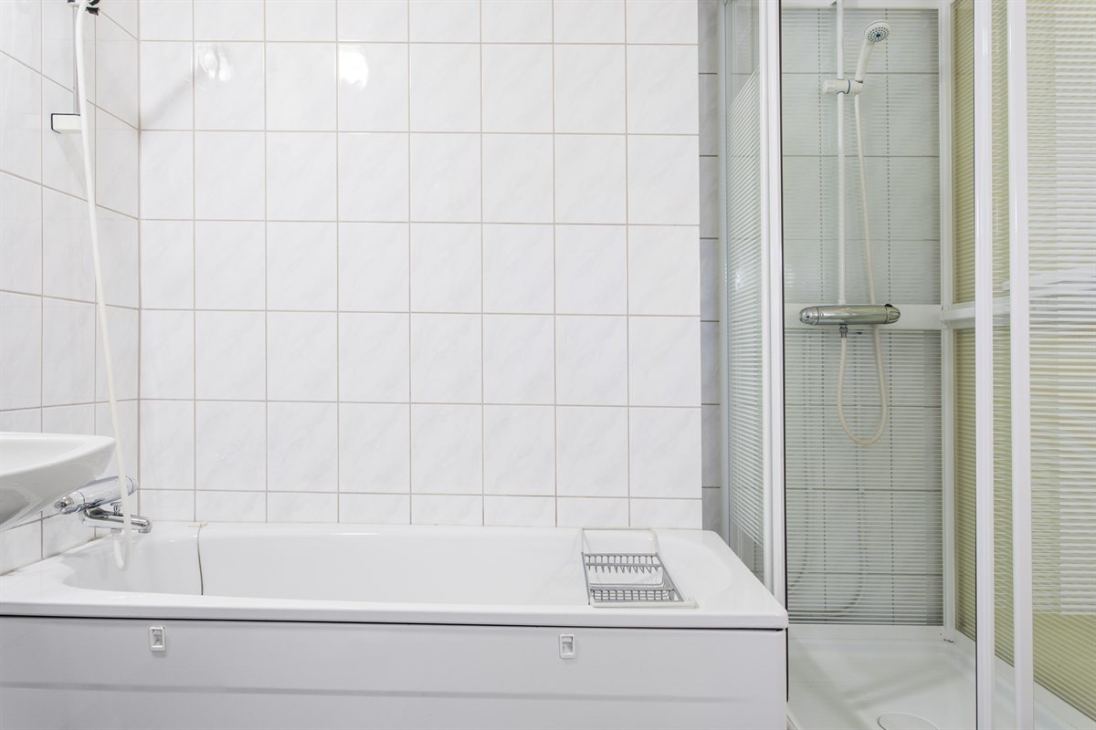 Badet er innredet med kar og kabinett, servant og toalett, samt opplegg for vaskemaskin Galleribilde