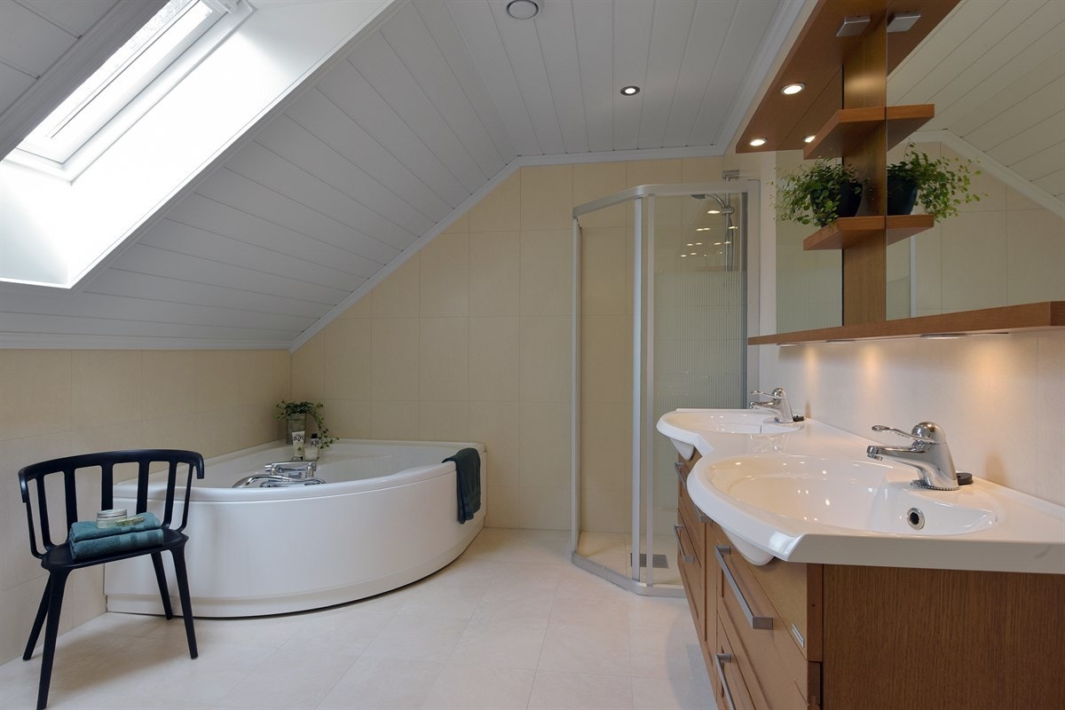 I andre etasje har boligen enda et delikat bad med sandfargede fliser på gulv og vegger, skråhimling med lysinnslipp via takvindu, downlights og gulvvarme. Galleribilde