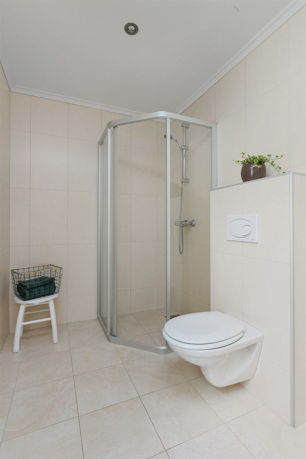 Badet i første etasje gir et delikat inntrykk med sandfargede fliser, gulvvarme, downlights og vindu for innslipp av naturlig lys. Galleribilde