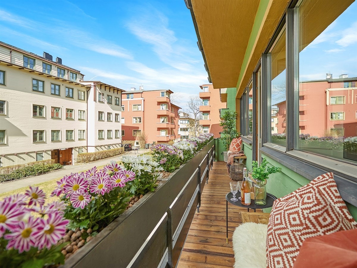 Balkongen er belagt med terrassebord og rekkverk av stål og tre Galleribilde