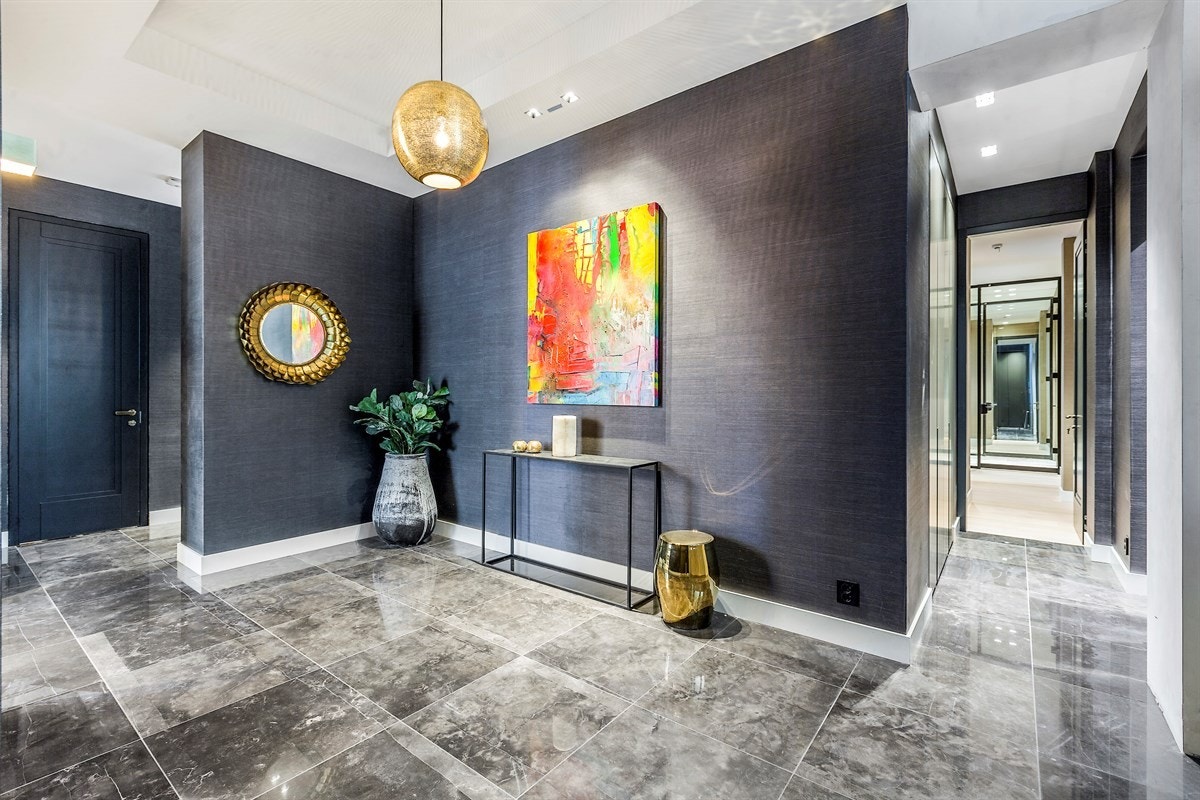 Nydelig hall med mørkt tapet og store naturstensfliser i 60 x 60. Galleribilde