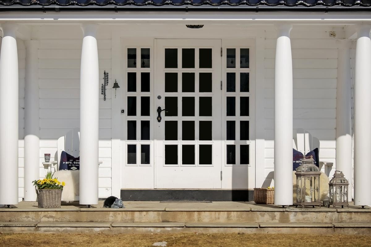 Hovedhuset har et pent inngangsparti med skifersten og en flott dør med glass og sidefelt Galleribilde