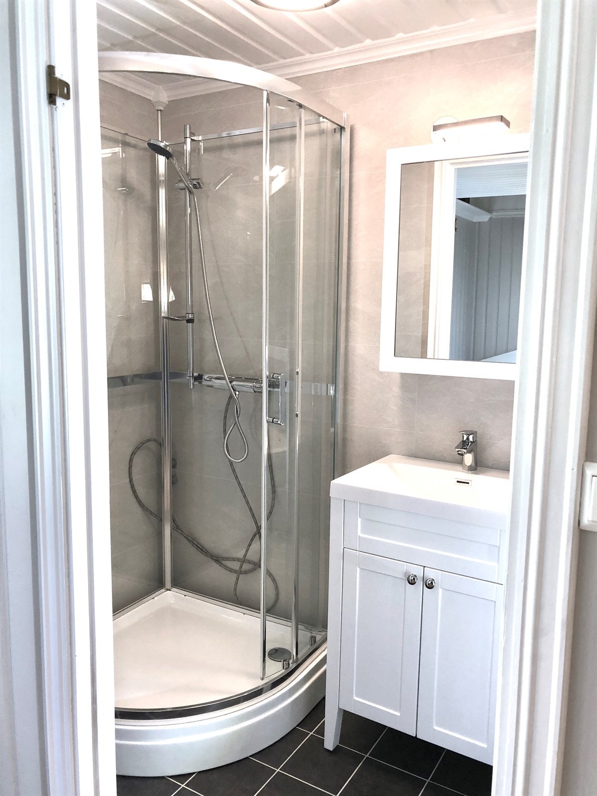 Et nyoppusset bad i 1.etg. med flislagte overflater og pene baderomsplater på vegg Galleribilde