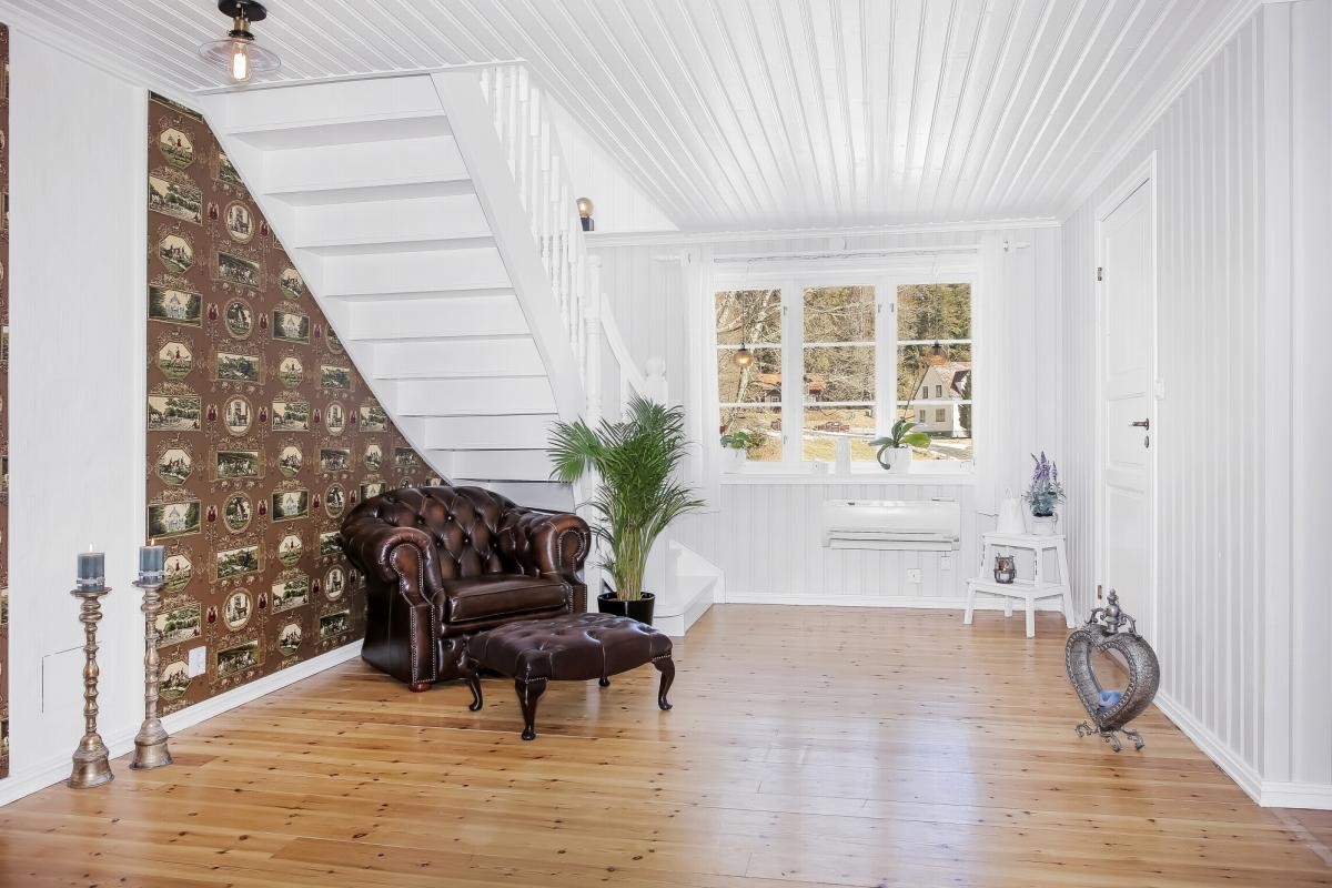 En meget romslig hall med trapp og lyse overflater Galleribilde