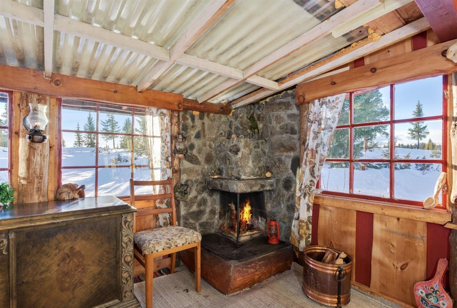 Overbygd terrasse med platetak og kledde vegger av bindingsverk. Peis. Galleribilde